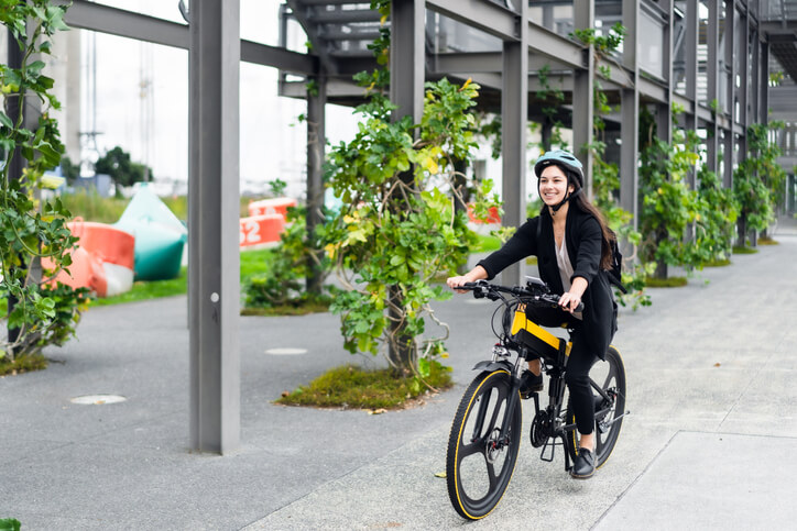 Femme avec casque sur vélo à assistance électrique assuré