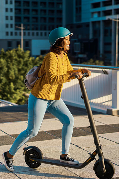 Femme sur trottinette électrique avec casque sécurité